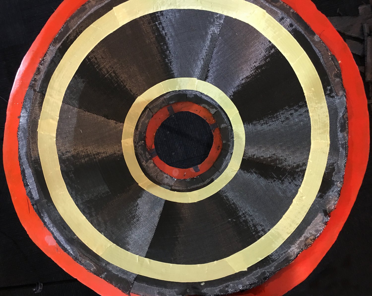 Laying up carbon and Kevlar fiber material for the HAPP's upper aeroshell on an orange mold